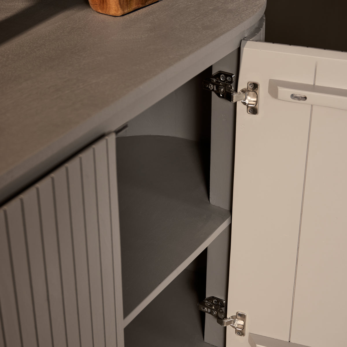 Detail van de afgeronde zijkant en deur van dressoir Solana taupe