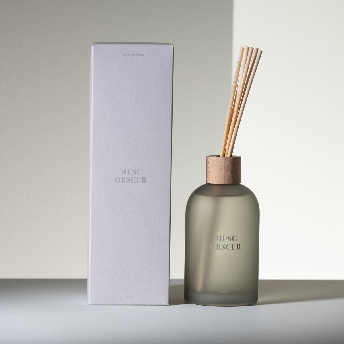 Geurstokjes Accords Essentiels Musc Obscur 250ml van J-Line met bijpassende doos in een sfeervolle grijze setting
