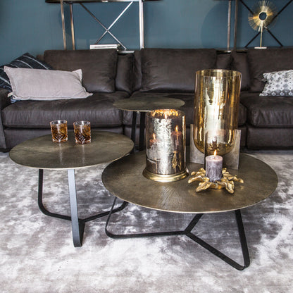 Kae salontafel Large van PTMD in goud aluminium als middelpunt van een zithoek, gecombineerd met kleinere Kae tafels