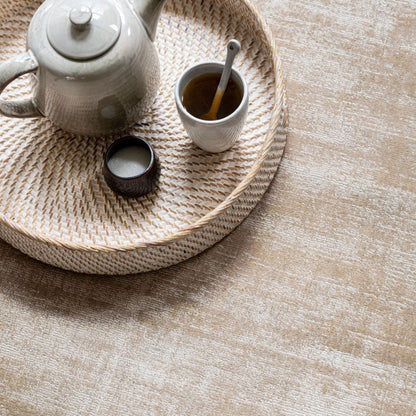 Vloerkleed La Belle van MUST Living, sfeerbeeld van het beige viscose vloerkleed in een lichte woonkamer