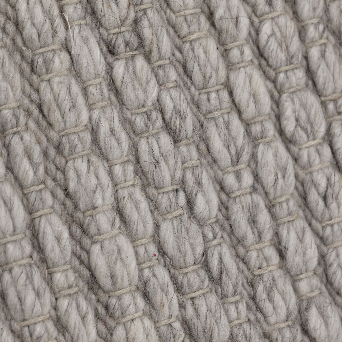 Detail van het grijze Nirvana vloerkleed van MUST Living met zichtbare wolvezels