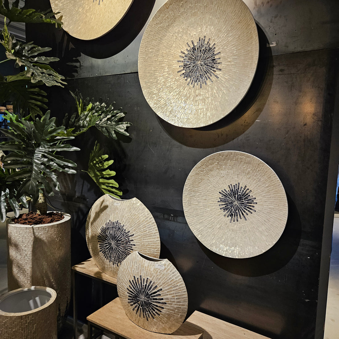 Wandpaneel Vojtech Wit Schelpen Bamboe Small van PTMD, drie schelpenpanelen aan een donkere muur met planten